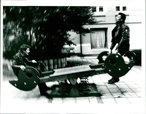 Homens tocando em uma serra de ver na área de recreação - foto da imprensa vintage